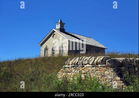 Die Lower Fox Creek School befindet sich auf einem Hügel im Tallgrass Prairie National Preserve in der Nähe von Strong City, Kansas. Alles, was von der alten Steinmauer übrig ist Stockfoto