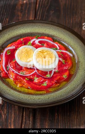 Zorongollo-Salat mit gebackenem Gemüsepaprika, Eiern, Zwiebeln und Tomaten Stockfoto