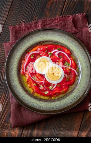 Zorongollo-Salat mit gebackenem Gemüsepaprika, Eiern, Zwiebeln und Tomaten Stockfoto