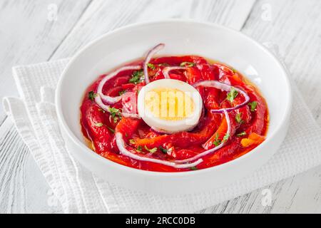 Zorongollo-Salat mit gebackenem Gemüsepaprika, Eiern, Zwiebeln und Tomaten Stockfoto