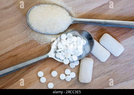 Leipzig, Deutschland. 12. Juli 2023. Ein Löffel voller Süßmitteltabletten befindet sich neben einem Löffel voller Zucker und Kaugummi mit Süßstoffen. Kredit: Hendrik Schmidt/dpa/Alamy Live News Stockfoto