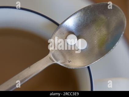 Leipzig, Deutschland. 12. Juli 2023. Ein Löffel mit zwei Süßstofftabletten liegt auf einer Tasse Kaffee. Kredit: Hendrik Schmidt/dpa/Alamy Live News Stockfoto