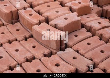 Gartenfliesen gebogener Ziegel, Palisade-Ziegel-Bordsteinpflaster im Lager auf Palette. Dekorieren Sie den Betonblock mit Rasen und Betonrand mit Zylindern für den Path Garden Exteri Stockfoto