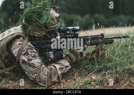 Offizierskadetten der britischen Armee bei der Royal Military Academy Sandhurst führen einen simulierten Angriff während der Akademie-Übung Dynamic Victory auf dem Grafenwoehr Trainingsgelände am 12. Juli 2023 durch. Die Übung und die Ausbildung in Deutschland sind Teil des Lehrplans, der zwischen einem Offizierskadetten und ihrer Beauftragung als Offizier in der britischen Armee liegt. (USA Armeefoto von SPC. Christian Carrillo) Stockfoto