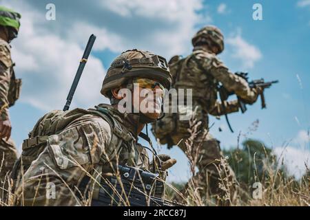 Offizierskadetten der britischen Armee bei der Royal Military Academy Sandhurst führen einen simulierten Angriff während der Akademie-Übung Dynamic Victory auf dem Grafenwoehr Trainingsgelände am 12. Juli 2023 durch. Die Übung und die Ausbildung in Deutschland sind Teil des Lehrplans, der zwischen einem Offizierskadetten und ihrer Beauftragung als Offizier in der britischen Armee liegt. (USA Armeefoto von SPC. Christian Carrillo) Stockfoto