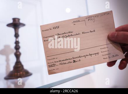 Hamm, Deutschland. 12. Juli 2023. Der Ursprung eines Kronleuchters, der aus der Synagoge in Hamm gestohlen wurde, ist auf einer Karteikarte aufgezeichnet. Das Gustav-Lübcke-Museum untersucht seine Besitztümer seit 2021 auf möglicherweise von den Nazis geplündertes Eigentum. Die Ausstellung „Missing Links“ vermittelt die historischen Kontexte von Antisemitismus, Verfolgung und Enteignung und erinnert an die Geschichte der Objekte und der Menschen, denen sie gehörten. Kredit: Oliver Berg/dpa/Alamy Live News Stockfoto