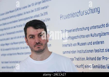 Hamm, Deutschland. 12. Juli 2023. Jan Giebel, Kunsthistoriker steht in der Ausstellung "Missing Links. Das Gustav-Lübcke-Museum untersucht seine Besitztümer seit 2021 auf möglicherweise von den Nazis geplündertes Eigentum. Die Ausstellung „Missing Links“ vermittelt die historischen Kontexte von Antisemitismus, Verfolgung und Enteignung und erinnert an die Geschichte der Objekte sowie an die Menschen, denen sie gehörten. Kredit: Oliver Berg/dpa/Alamy Live News Stockfoto