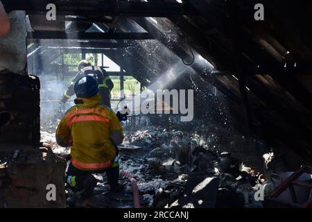 Verkhnya Tersa, Ukraine. 13. Juli 2023. Die ukrainischen staatlichen Rettungsdienste Feuerwehrleute löschten das Feuer, nachdem ein russischer Granatwerfer ein Privathaus im Dorf Verkhnya Tersa getroffen hatte. Am 505. Tag des groß angelegten russischen Krieges gegen die Ukraine laufen schwere Kämpfe an den Fronten Kupiansk, Lyman, Bakhmut, Avdiivka und Marinka. An der Front von Zaporizhien und Kherson versuchen die Russen, die ukrainischen Streitkräfte am Vorrücken zu hindern. Kredit: SOPA Images Limited/Alamy Live News Stockfoto