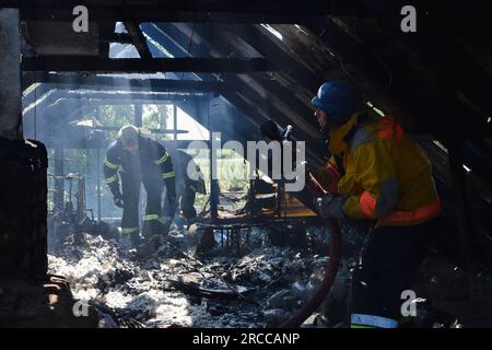 Verkhnya Tersa, Ukraine. 13. Juli 2023. Die ukrainischen staatlichen Rettungsdienste Feuerwehrleute löschten das Feuer, nachdem ein russischer Granatwerfer ein Privathaus im Dorf Verkhnya Tersa getroffen hatte. Am 505. Tag des groß angelegten russischen Krieges gegen die Ukraine laufen schwere Kämpfe an den Fronten Kupiansk, Lyman, Bakhmut, Avdiivka und Marinka. An der Front von Zaporizhien und Kherson versuchen die Russen, die ukrainischen Streitkräfte am Vorrücken zu hindern. Kredit: SOPA Images Limited/Alamy Live News Stockfoto