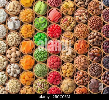 Gemischte Nüsse und getrocknete Früchte als Hintergrund. Bio-Lebensmittel in Holzschüsseln, Draufsicht. Stockfoto