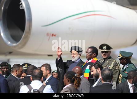 Harare, Simbabwe. 13. Juli 2023. Der Präsident Simbabwes Emmerson Mnangagwa (2. L, Rückseite) begrüßt den iranischen Präsidenten Ebrahim Raisi (1. L, Rückseite) am 13. Juli 2023 in Harare (Simbabwe). Der iranische Präsident Ebrahim Raisi schloss seine Afrika-Tour mit drei Nationen am Donnerstag mit einem eintägigen Staatsbesuch in Simbabwe ab. Kredit: Shaun Jusa/Xinhua/Alamy Live News Stockfoto