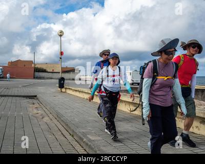 13. Juni 2023, Aguacadoura, PÃ³voa de Varzim, Portugal: Eine Gruppe asiatischer Pilger ist auf der Strecke zu sehen. Die Küstenstraße des portugiesischen Camino ist eine schöne Alternative zu Fuß zur Central Route. Die Gesamtstrecke beträgt 280 km Sie beginnt in Porto und folgt der Küste bis Redondela in Spanien, wo sie mit der Central Route verschmolzen wird. Etwa 30 % der Pilger, die den portugiesischen Camino vollenden, gehen entlang der Küstenstraße. Der portugiesische Camino wird immer beliebter, und viele Pilger wählen diese Route als Alternative zu den Camino Frances. Küstenroute Portugals Stockfoto