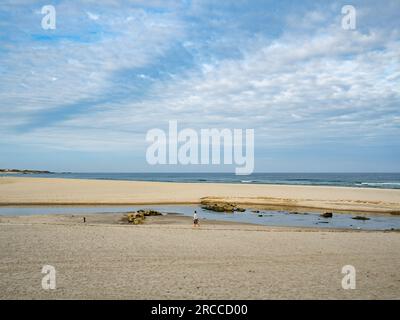 11. Juni 2023, Vila Praia de Ã‚ncora, Portugal: Eine Frau wird gesehen, wie sie an einem einsamen Strand spaziert. Die Küstenstraße des portugiesischen Camino ist eine schöne Alternative zu Fuß zur Central Route. Die Gesamtstrecke beträgt 280 km Sie beginnt in Porto und folgt der Küste bis Redondela in Spanien, wo sie mit der Central Route verschmolzen wird. Etwa 30 % der Pilger, die den portugiesischen Camino vollenden, gehen entlang der Küstenstraße. Der portugiesische Camino wird immer beliebter, und viele Pilger wählen diese Route als Alternative zu den Camino Frances. Die Küstenstraße des portugiesischen Camino ist ein Verehrer Stockfoto