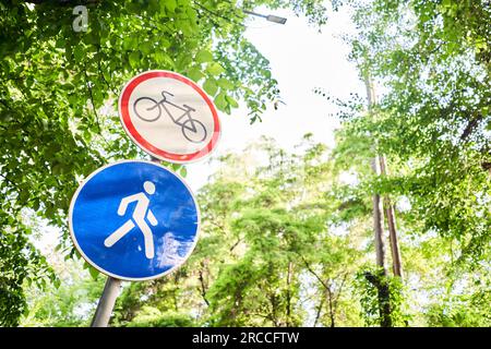 Fahrrad- und Fußgängerschilder im Sommer. Italien. Blick auf ein generisches Schild „Fahrradrennen verboten“ auf einem Fußgängerweg. Das „kein Radfahren“-Zeichen bedeutet, dass die Verwendung von verwendet wird Stockfoto