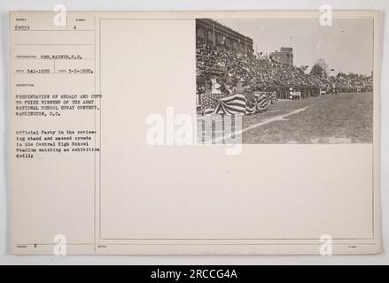 Das Bild zeigt die Präsentation von Medaillen und Pokalen an die Gewinner des Army National School Essay Contest in Washington, D.C. Das Foto wurde am 5. Mai 1920 aufgenommen und zeigt eine offizielle Party am Rezensionsstand, zusammen mit großen Menschenmassen im Central High School Stadium, die eine Ausstellungsübung beobachten. Stockfoto