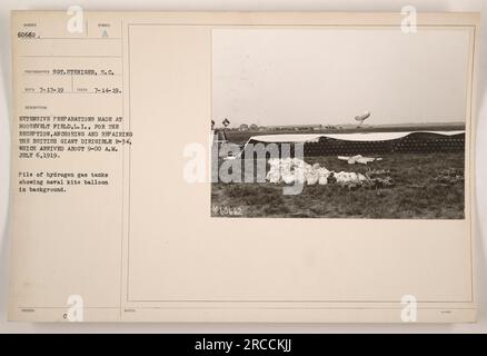 Vorbereitungen auf dem Roosevelt-Feld, L.I. für die Ankunft und Reparatur des britischen Luftschiffs R-34. Das Foto zeigt einen Haufen Wasserstoffgastanks mit einem Marinedrachenballon im Hintergrund. Sgt. Steniger hat dieses Bild am 14. Juli 1919 aufgenommen. Zusammen mit dem Hinweis 960662 1-0000 ausgegeben. Stockfoto