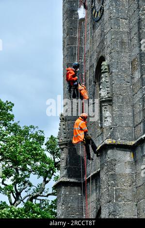 Widecombe im Moor - Arbeiten an der Uhr der St. Pancras-Kirche durch Abseilen von Arbeitskräften Stockfoto