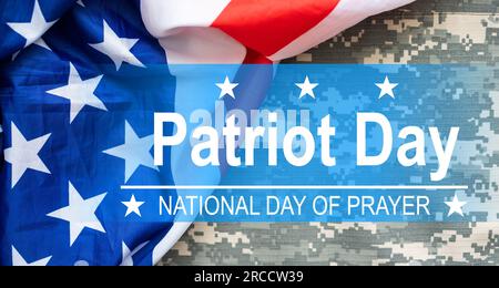 Die Worte Patriot Day 09.11.01 wurden mit silbernen Metallbuchstaben auf Holzbrettfläche mit zerknitterter us-Flagge unten mit Nahaufnahme diagonaler Perspektive gelegt Stockfoto