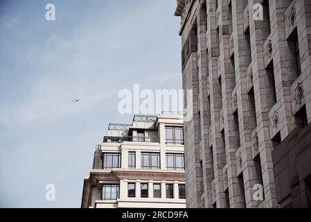 Flugzeug, das über Stadtgebäude fliegt Stockfoto