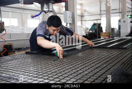 ZHANGJIAKOU, CHINA – 14. JULI 2023 – ein Mitarbeiter von Zhangjiakou Kono Engineering Plastics Co., Ltd. Arbeitet an einer Produktionslinie A für künstliche Eisplatten Stockfoto