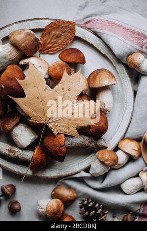 Holzschale mit Waldpilzen und Herbsttrockenblatt. Stockfoto