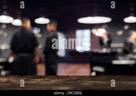 Platz für Werbung und Dekoration auf einem Holztisch, unscharfer Blick auf den Friseur. Stockfoto
