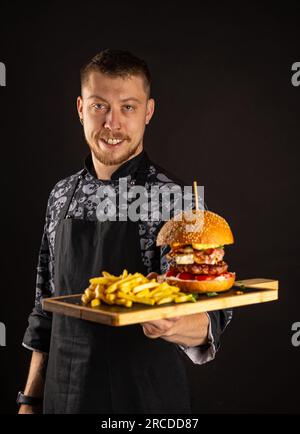 Street Food ist servierfertig. Großer Burger mit Pommes Frites Stockfoto