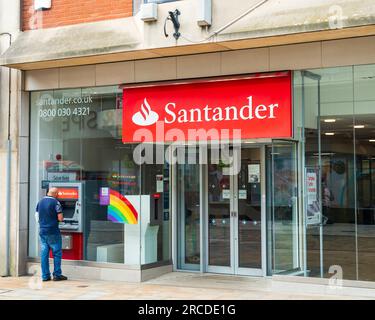 Wolverhampton, Vereinigtes Königreich - Juli 13 2023: Fronttage einer Santander Bank, einschließlich Person, die den Geldautomaten in Wolverhampton, Vereinigtes Königreich nutzt Stockfoto