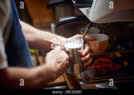 Detail eines Weißen, der Milchschaum für einen Kaffee macht Stockfoto