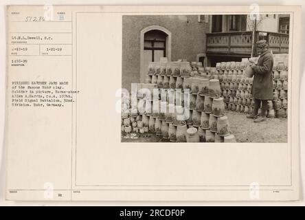 Soldat Allen A. Harris wird in Hohr fotografiert und hält fertige Erdgläser aus dem berühmten Lehm Hohr. Er ist ein Pferdeschuh in Co A, 107. Feldsignalbataillon, 32. Division. Das Foto wurde am 15. April 1919 von Lieutenant N.L. aufgenommen Dewell mit der Fotografen-ID 51284. Stockfoto