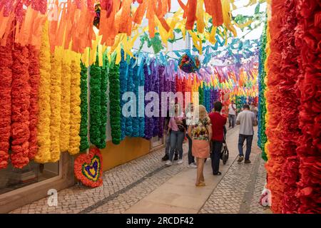 Tomar, Portugal - 8. Juli 2023: Straße der Stadt Tomar in Portugal, dekoriert mit Regenbogenfarben auf Papierblumen während der Festa dos Tabuleiro Stockfoto