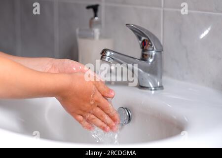 Ein Kind, das sich vor dem Essen im Bad die Hände wäscht. Hygiene, Sauberkeitskonzept. Umweltschutz und die Rettung des Planeten Stockfoto