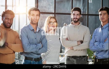 Geschäftsleute stehen in einem modernen Büro und schauen geradeaus Stockfoto
