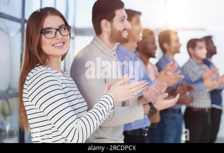 Nebenprofil von Geschäftsführern, die hintereinander klatschen und lächeln Stockfoto