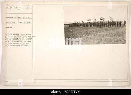 Das Bild zeigt einen Moment von der Präsentation der Number Division zur Durchsicht des Distinguished Service Cross (D.S. .C) bis zu 36 Offizieren und Männern der 5. Division. Die Präsentation wird von Divisionskommandeur Generalmajor Hanson E. Ely durchgeführt. Der Farbwächter steht auf der Hut, während der Star Spangled Banner gespielt wird. Diese Veranstaltung fand am 30. Dezember 1918 in Esch (Luxemburg) statt. Sie hat die Nummer 111-SC-44587 und wurde von LT. WM aufgenommen. Fox, S.C. Das Foto wurde am 1. März 1919 herausgegeben und es gibt zusätzliche Hinweise mit der Bezeichnung 9 Mc. Stockfoto