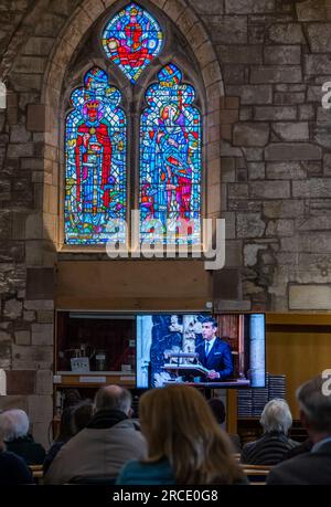 Menschen, die die Krönung von König Karl III. Auf einem Fernsehbildschirm mit Rishi Sunak, St. Mary's Parish Church, Haddington, East Lothian, Schottland, Großbritannien, verfolgen Stockfoto