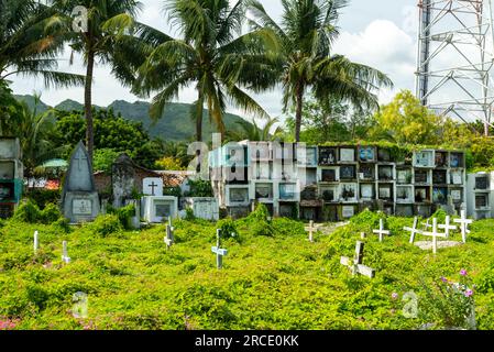 Interessanter Friedhof, am Meer in Oslob, voller Gräber, Gräber und Kammern, in denen die Verstorbenen untergebracht sind, Hunderte von weißen Kruzifixen, inmitten von, ra Stockfoto