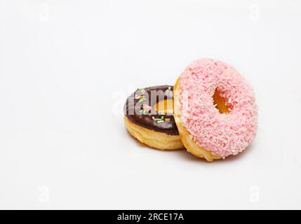 Pinkfarbene Donuts und Schokolade isoliert auf weißem Hintergrund. Stockfoto