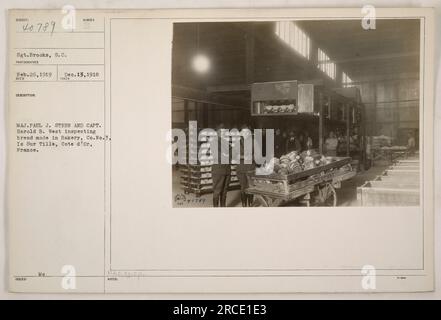 "Major Paul J. Stern und Captain Harold B. West untersuchen Brot Made in Bakery, Co. No. 3, in IS-sur-Tille, Cote d'Or, Frankreich. Das Foto wurde am 26. Februar 1919 von Sergeant S.C. Brooks aufgenommen. Es war Teil der Fotografien der amerikanischen Militäraktivitäten während des Ersten Weltkriegs, herausgegeben mit der Referenznummer 111-SC-40789." Stockfoto