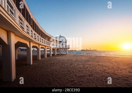 La Caleta Beach, Balneario de la Palma Gebäude und Schloss von San Sebastian bei Sonnenuntergang - Cadiz, Andalusien, Spanien Stockfoto