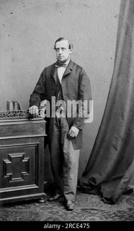 Foto in voller Länge von einem Gentleman, der auf einer Seitenwand steht. Originalfoto von William Elliott Debenham aus dem Jahr 158, Regent Street, London. Aus einer Sammlung viktorianischer Carte de Visite Fotografien aus den 1890er Jahren. Carte de visite ist ein französischer Begriff, der auf Englisch als „Visitenkarte“ bezeichnet wird. Normalerweise wurde ein Fotodruck aus Albumen von etwa 54 x 89 mm auf einer etwas größeren Karte angebracht. In einigen Fällen haben die Verwüstungen der Zeit ihren Tribut gefordert. Stockfoto