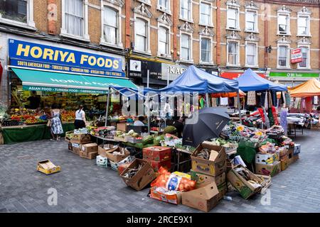 Der lebendige Brixton Market auf der Electric Avenue in der vielfältigen Gemeinde Brixton am 22. Juni 2023 in London, Großbritannien. Brixton ist ein Bezirk in Süd-London, England, im Londoner Stadtteil Lambeth. Brixton ist überwiegend Wohnimmobilien mit einem bedeutenden Straßenmarkt und einem bedeutenden Einzelhandelssektor. Es ist eine multikulturelle Gemeinschaft mit einem großen Anteil ihrer Bevölkerung afro-karibischer Abstammung, die Brixton zur inoffiziellen Hauptstadt der britischen afro-karibischen Gemeinschaft macht. Stockfoto