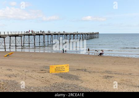 Saltburn Pier mit RNLI Lifeguard Swimming Information Banner, Saltburn-by-the-Sea, North Yorkshire, Großbritannien Stockfoto