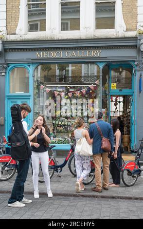 Junge Leute in der Thurloe Street vor der Medici Galerie, um sich zu treffen, Grußkarten und Souvenirladen. South Kensington, London, England, Großbritannien Stockfoto