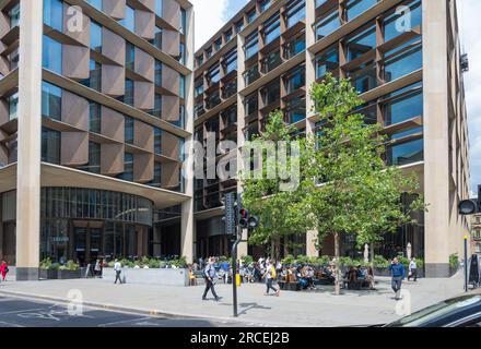 Die Stadtarbeiter sitzen mittags auf dem kleinen Platz der Bloomberg Arcade. Ecke Cannon Street und Wallbrook. City of London, England, Großbritannien Stockfoto