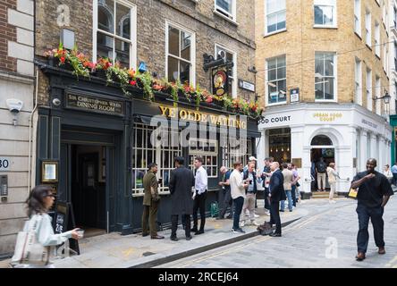 Leute unterwegs zur Mittagszeit. Gruppen von Männern stehen und trinken vor dem Ye Olde Watling Pub. Watling Street, City of London, England, Großbritannien Stockfoto