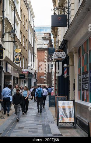 Arbeiter der Londoner City spazieren in der Bow Lane, einer schmalen Gasse mit Geschäften und Cafés und einer der ältesten noch existierenden Gassen der Stadt, England, Großbritannien Stockfoto