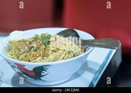 Mie Ayam ist ein beliebtes indonesisches Gericht, bestehend aus schmackhaften, herzhaften Hühnernudeln. Das Gericht besteht in der Regel aus dünnen gelben Nudeln, die in einem Fla serviert werden Stockfoto