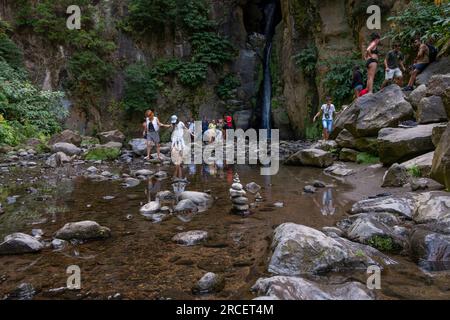 Ribeira Grande, Azoren - 05.09.2019: Touristen stehen in der Nähe des Wasserfalls von „Salto do Cabrito“. Die Insel Sao Miguel auf den Azoren Stockfoto