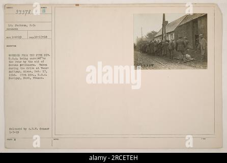 Titel: Erster Weltkrieg: LT. Jackson wird von deutschen Gefangenen unterstützt Beschreibung: LT. Jackson von der 27. Division, USA, wurde während der Fahrt in Vaux-Andigny, Aisne am 17. Oktober 1918 verwundet und wird von deutschen Gefangenen nach hinten getragen. Dieses Foto wurde in Busigny, Nord, Frankreich aufgenommen. Veröffentlicht von A.E.F. Zensor am 7. Januar 1919. Stockfoto